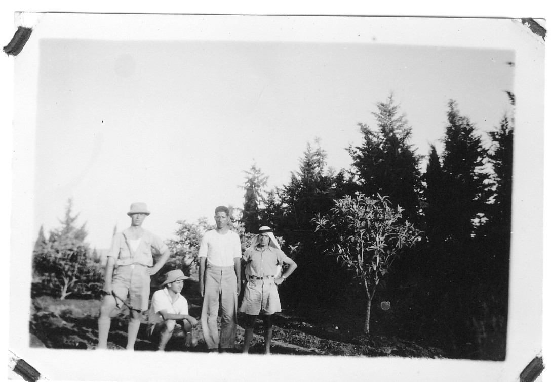 Album snapshot, circa 1938: four farmers of Nahalal standing among young trees planted on tilled Jezreel Valley soil
